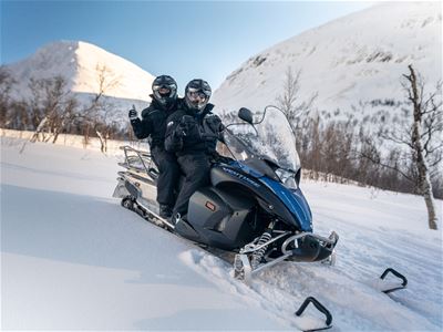 Gjester poserer på snøskuteren