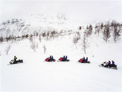 Snøskutere kjører i rekke